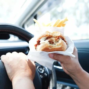 車でハンバーガーを食べる人