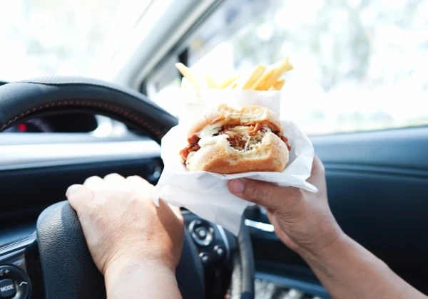 車でハンバーガーを食べる人
