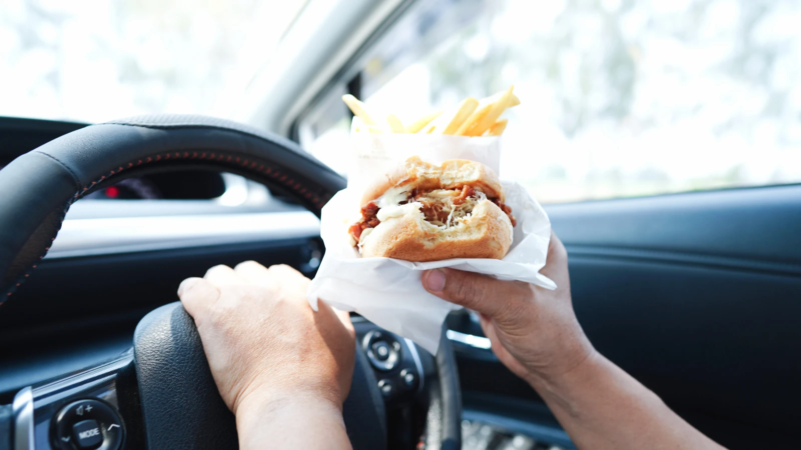車でハンバーガーを食べる人