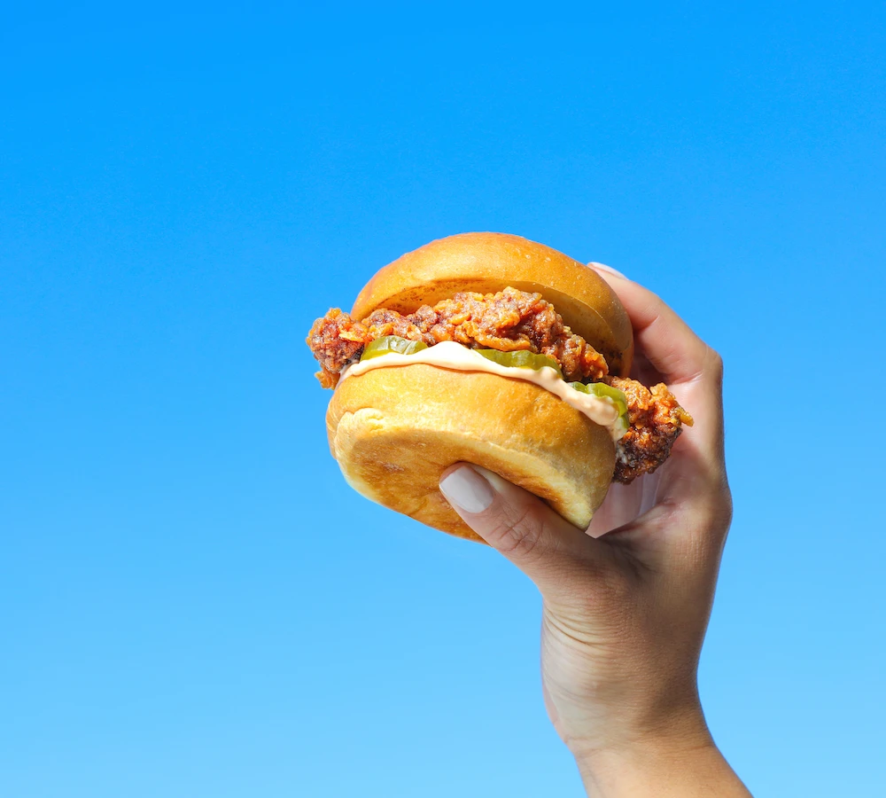 ハンバーガーを掲げる